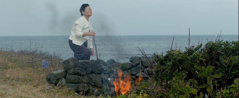 Stilbillede der viser person i landskab fra videoinstallationen Community of Parting af Jane Jin Kaisen