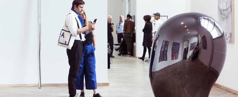 Personer står over for kunstværk i udstillingslokale