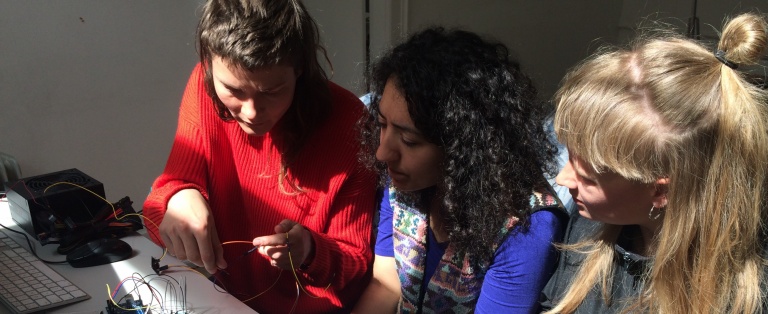 Tre studerende sidder ved et bord og arbejder med ledninger