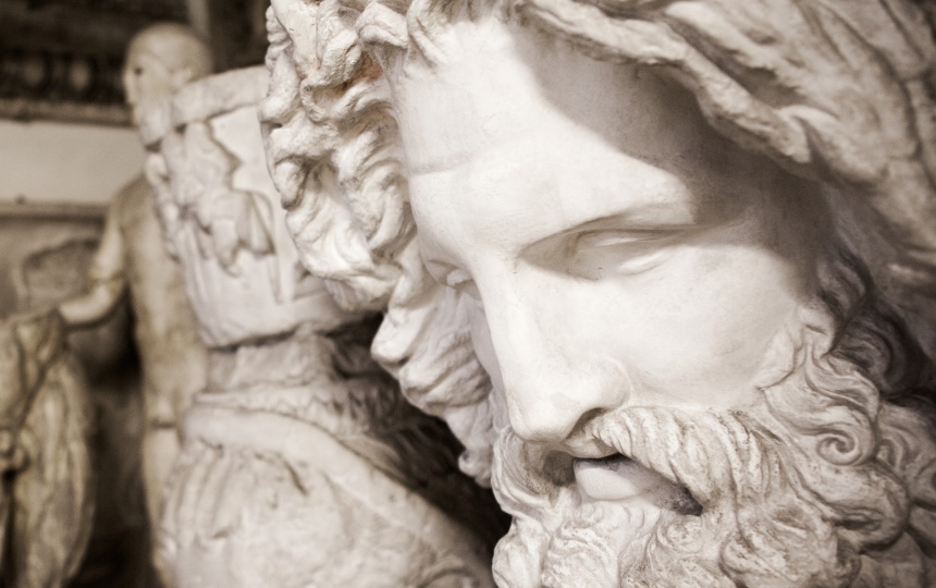 Menneskehoved med skæg og langt hår i gips og andre gipsskulpturer i baggrunden