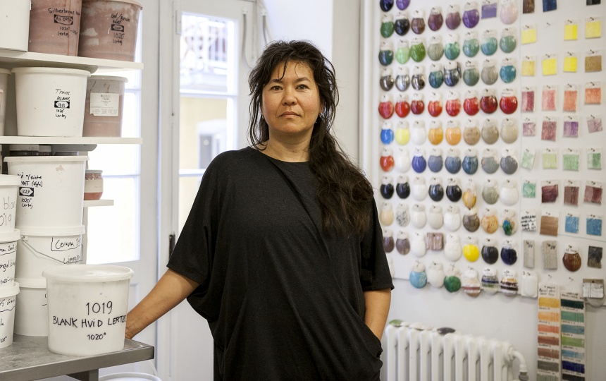 Lektor og leder af Labaratoriet for Keramik Karen Harsbo foran væg med glasurprøver