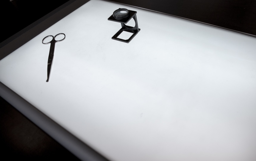 Saks og forstørrelsesglas på lysbord på Laboratoriet for fotografi