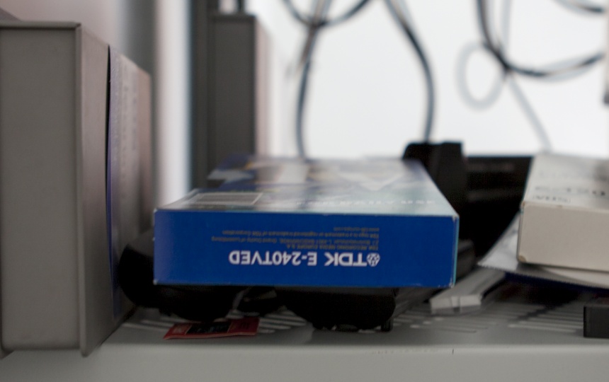 Æsker og bog på hylde med kabler og ledninger i baggrunden