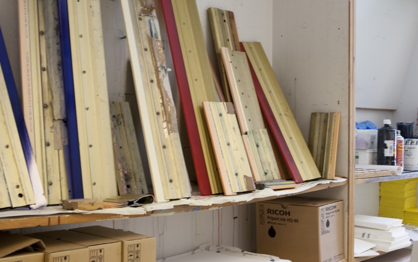 Metalstykker og papkasser med printerblæk på hylder