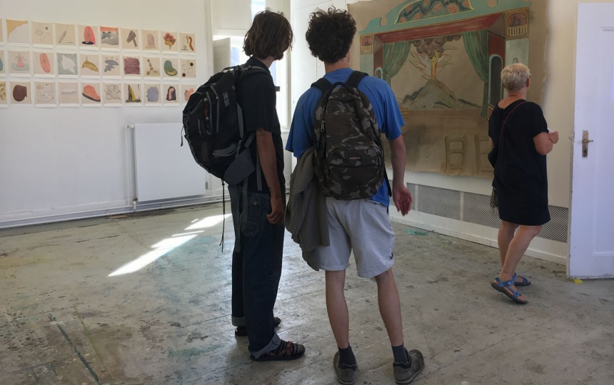 Personer kigger på kunstværk på væg