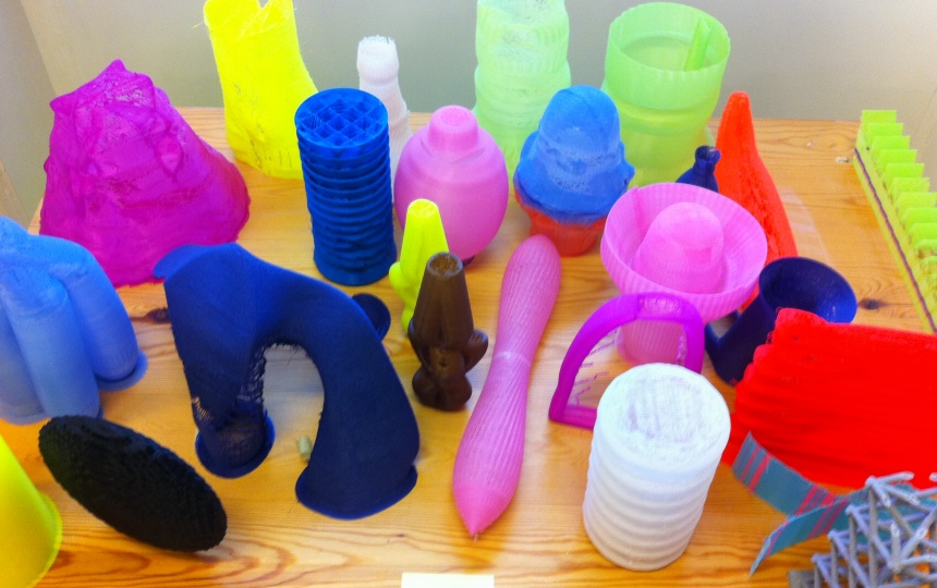 Farverige 3D-printede genstande i plastik på træbord i Laboratoriet for 3D